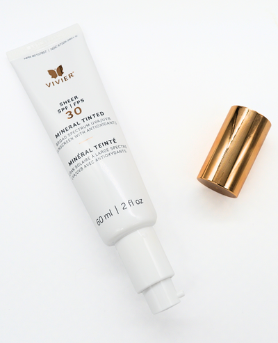 Vivier SHEER SPF 30 Mineral Tinted sunscreen tube with metallic cap, offering broad-spectrum protection and skin brightening benefits.