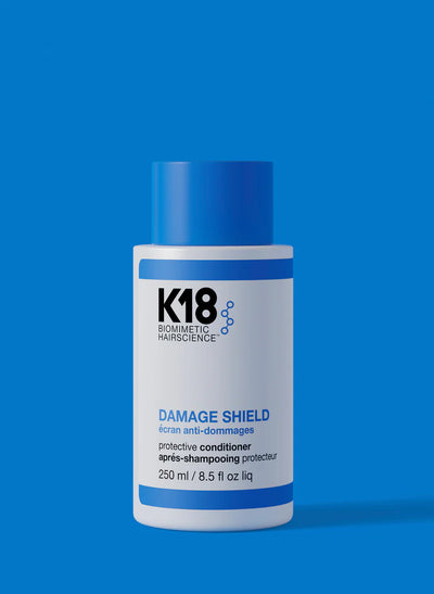 K18 DAMAGE SHIELD Protective Conditioner bottle on a blue background, 250ml size for hair protection and nourishment.