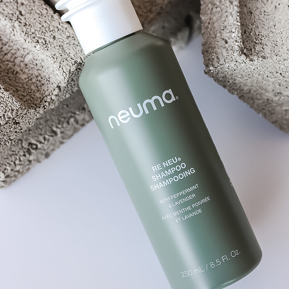 Re Neu Clarifying Shampoo bottle with peppermint and vanilla aroma on a neutral background.