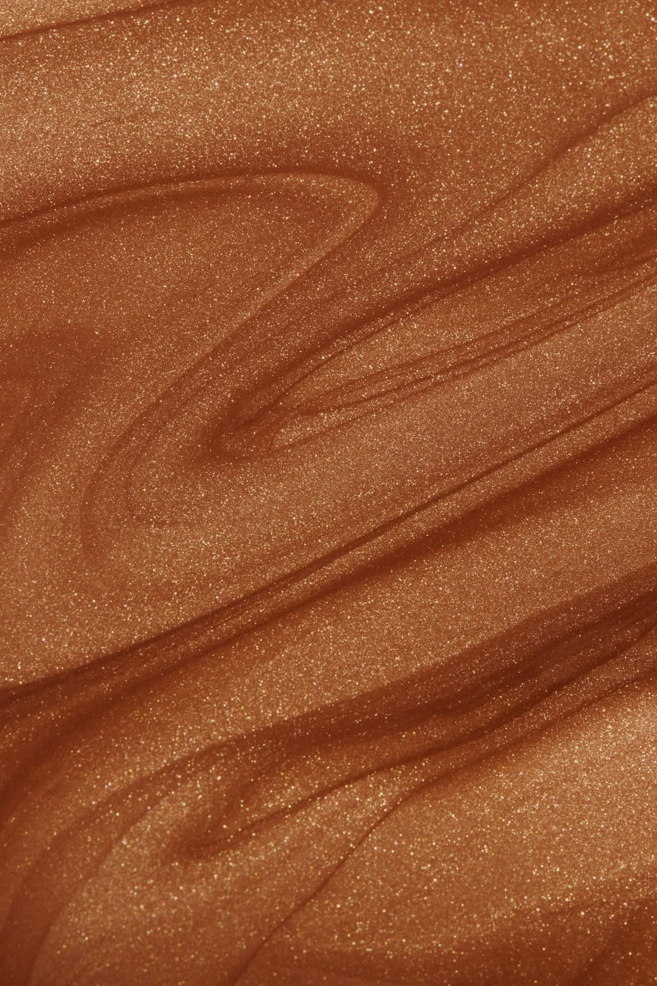 shimmering bronze liquid texture showcasing Nuda's Bronzing Glow Drops for a radiant, sun-kissed look.