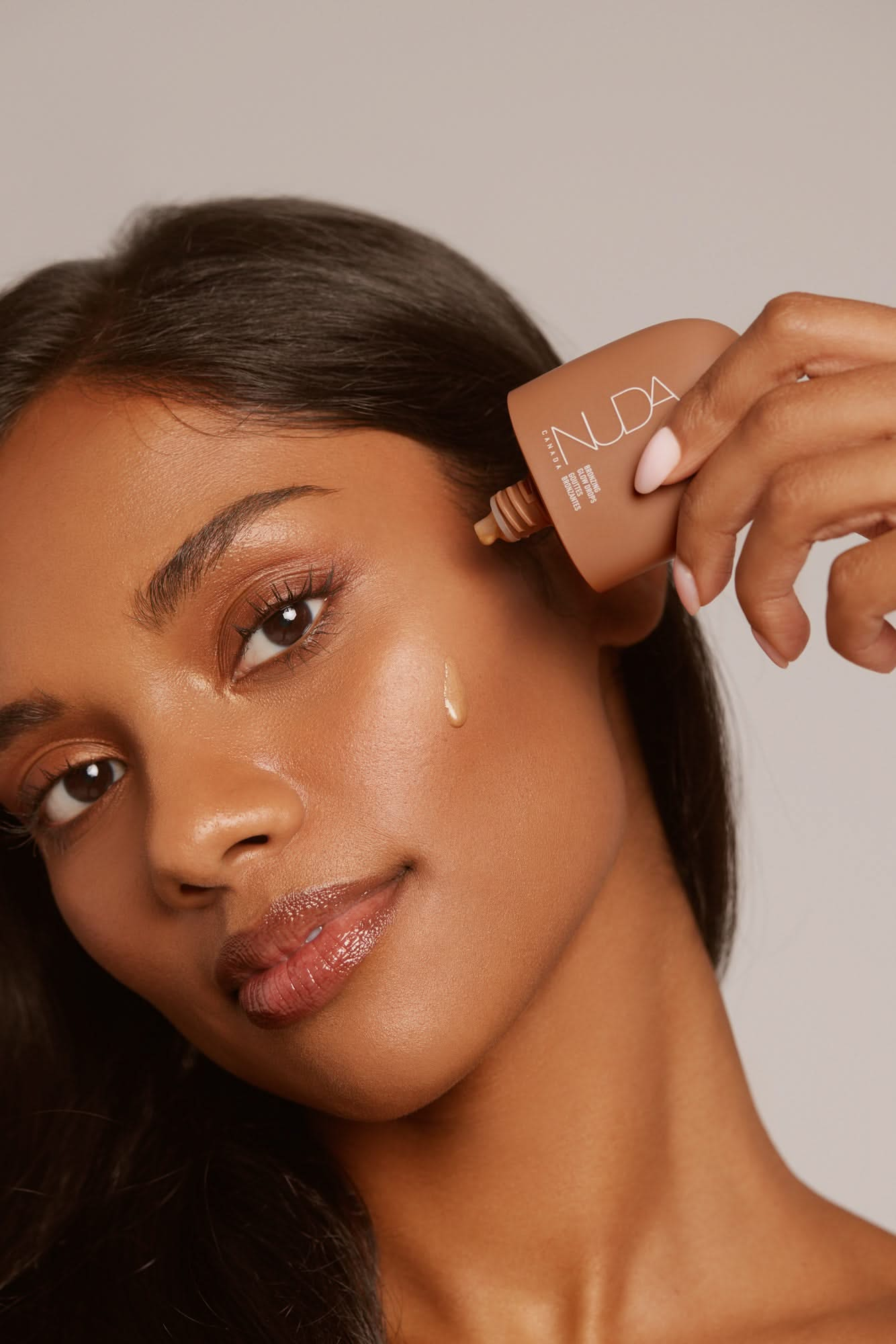 Woman applying facial self tanner for a radiant bronzed complexion from the Deluxe Bronzed Kit.