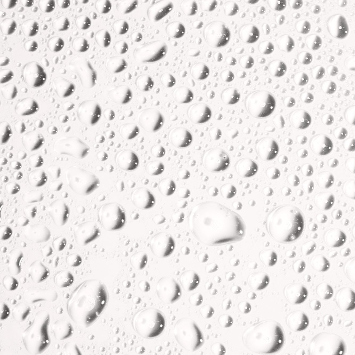 Close-up of clear water droplets on a smooth surface, highlighting freshness and hydration.