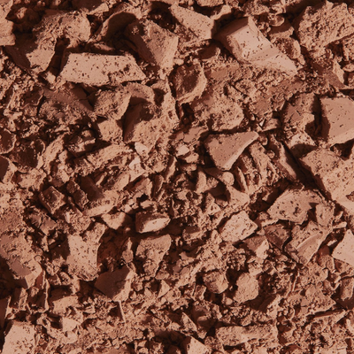 Matte bronzing powder texture, showcasing crushed bronzer in a rich, warm brown hue, ideal for achieving a natural tan.