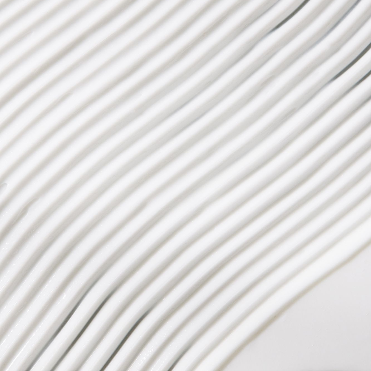 Close-up of textured white surface with wavy lines, showcasing smooth design and modern aesthetics.