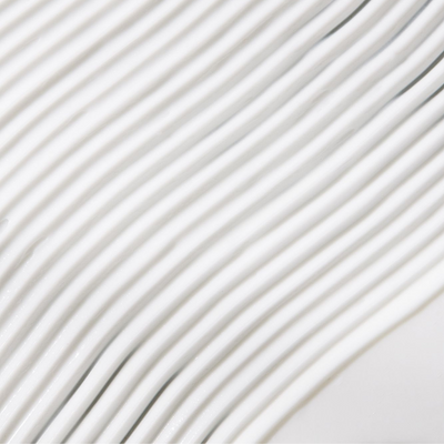 Close-up of textured white surface with wavy lines, showcasing smooth design and modern aesthetics.