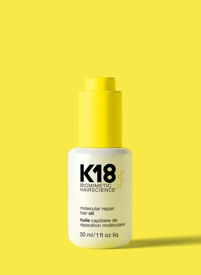 K18 Molecular Repair Hair Oil in a sleek white bottle with a yellow cap, ideal for strengthening and repairing hair.