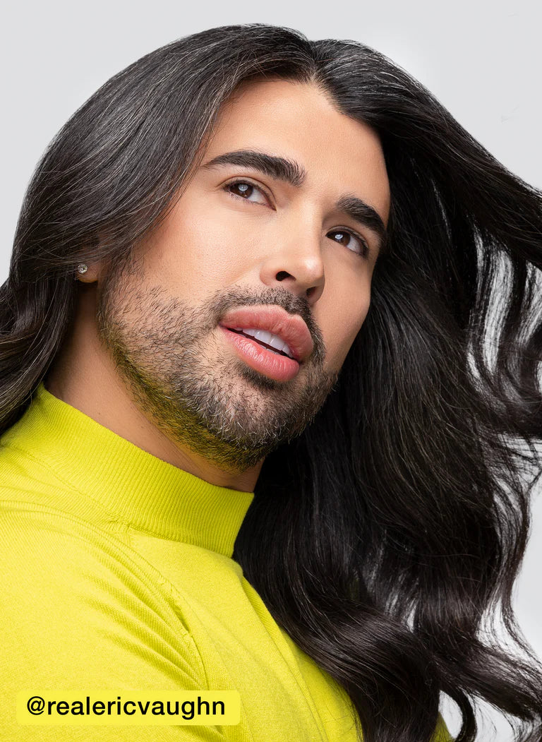 Model showcasing shiny, smooth hair with a vibrant yellow sweater, highlighting hair health and style.