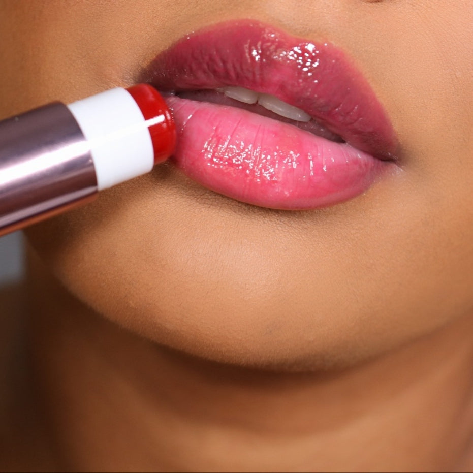 Close-up of glossy lips applying Girlactik Jello Gloss Balm in vibrant pink shade for a smooth, shiny finish.