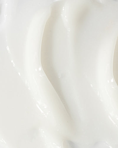 Close-up of creamy, lightweight lotion for acne treatment, showcasing its smooth texture and consistency.