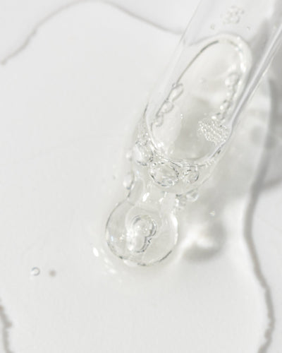 Close-up of Vivier Kine-C serum with droplets highlighting its lightweight, oil-free formula.