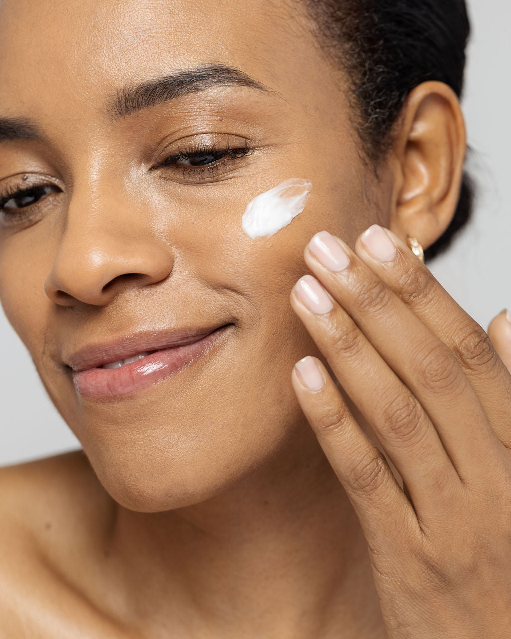 Woman applying Vivier LEXXEL moisturizer on her face, showcasing hydration and skin soothing benefits.