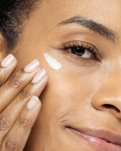 Close-up of a woman applying Vivier Radiant Eye Contour Cream to nourish and hydrate her under-eye area.