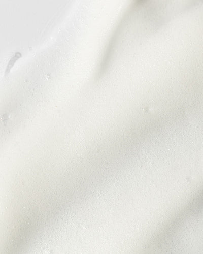 Close-up of creamy foaming cleanser showcasing its rich, airy texture for deep cleansing and hydration.