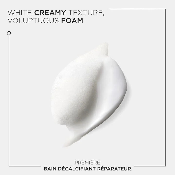 White creamy texture and voluptuous foam of Première Bain Décalcifiant Réparateur shampoo for damaged hair care.