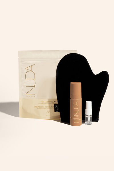 Nuda Self Tan Travel Kit featuring tanning lotion, applicator mitt, and travel-sized spray for flawless skin on the go.