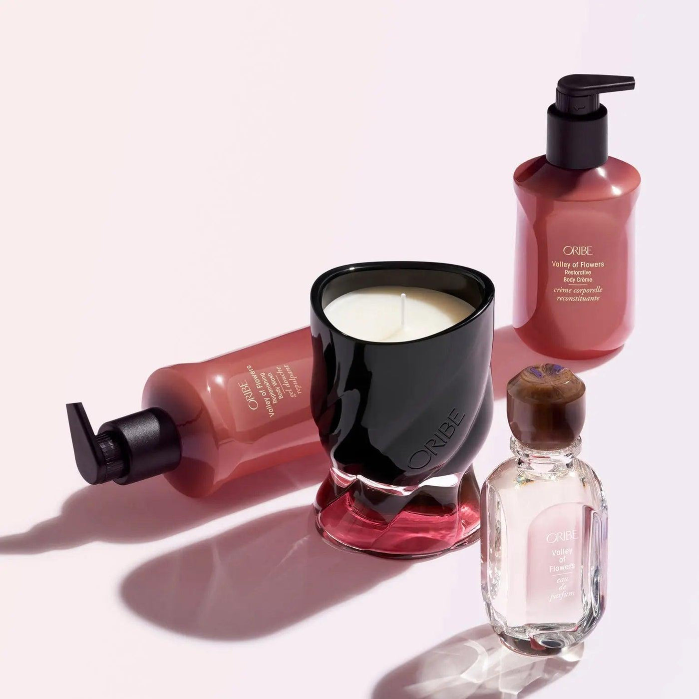 ORIBE Valley of Flowers body care products including crème, candle, and oil on a light background.