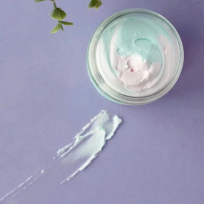 Whipped soap in a glass jar with a cotton candy scent, featuring fluffy texture on purple background.